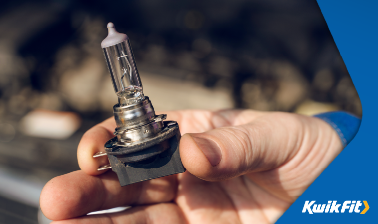 a headlight bulb held by a person