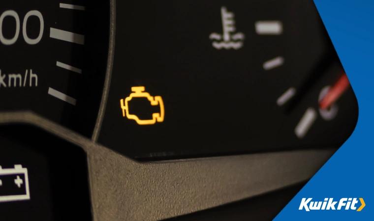Close up of an illuminated check engine light � shaped like a stylised outline of an engine.